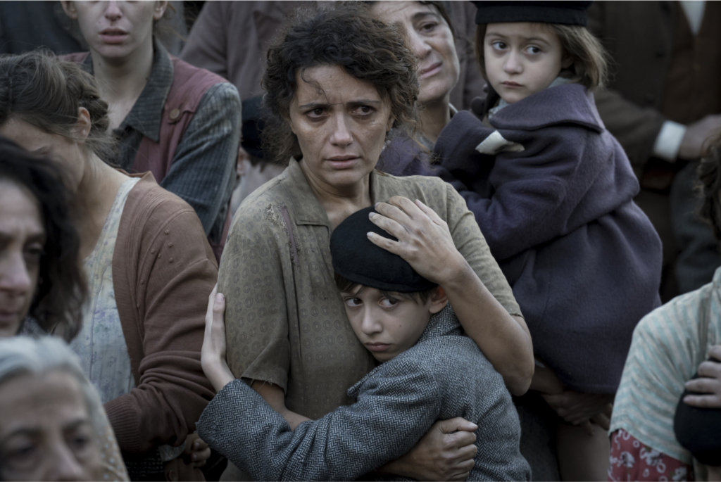 Mujer italiana entre la multitud abrazando a su hijo