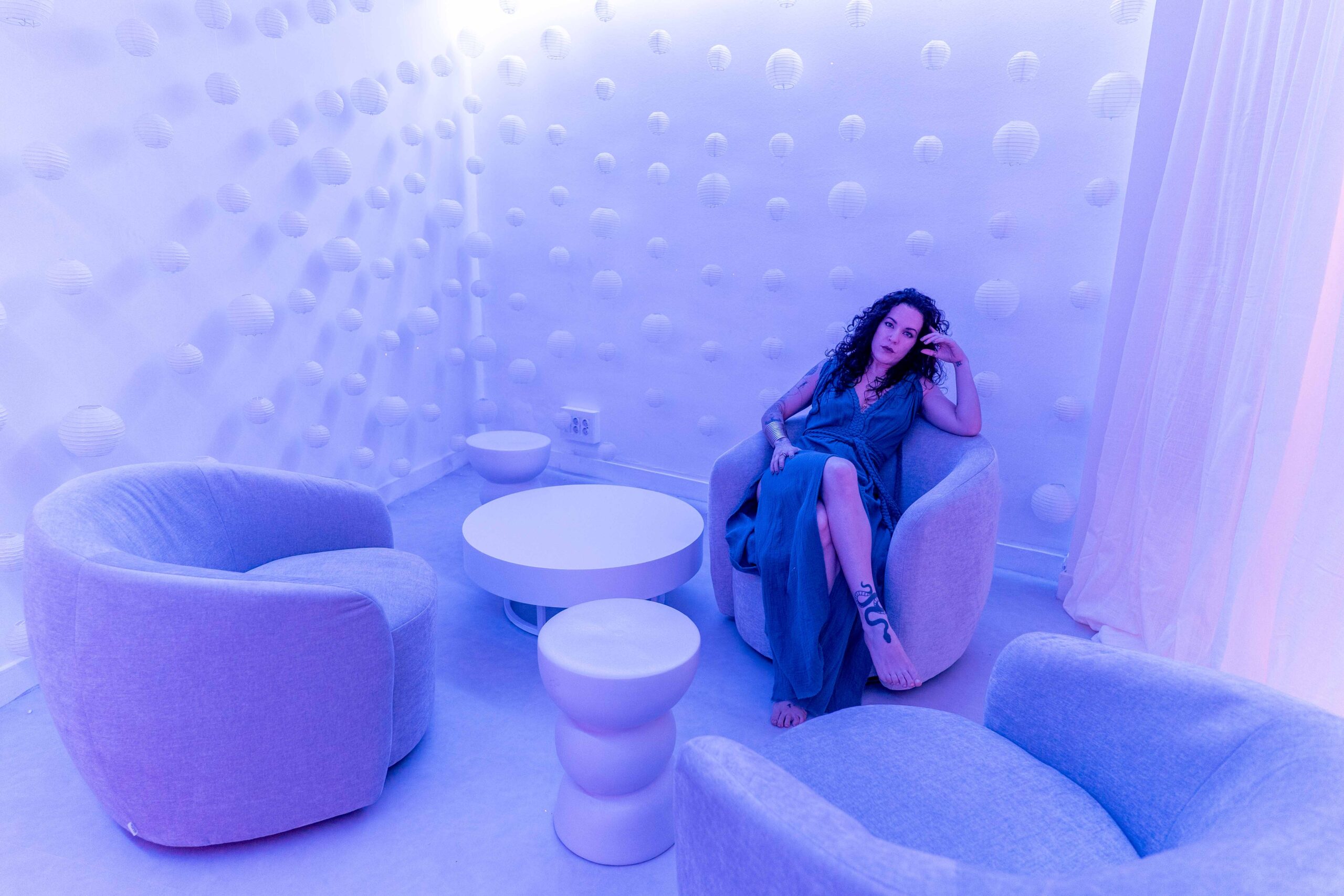 Noemí Casquet sentada en un sofá con tonos azules