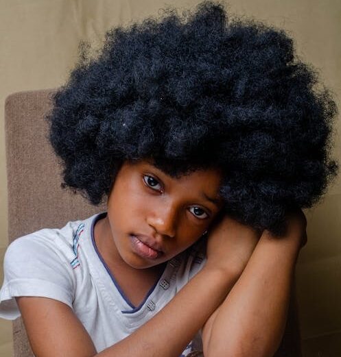 Niña de pelo afro mirando a la cámara