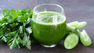 Zumo verde en un vaso y limón